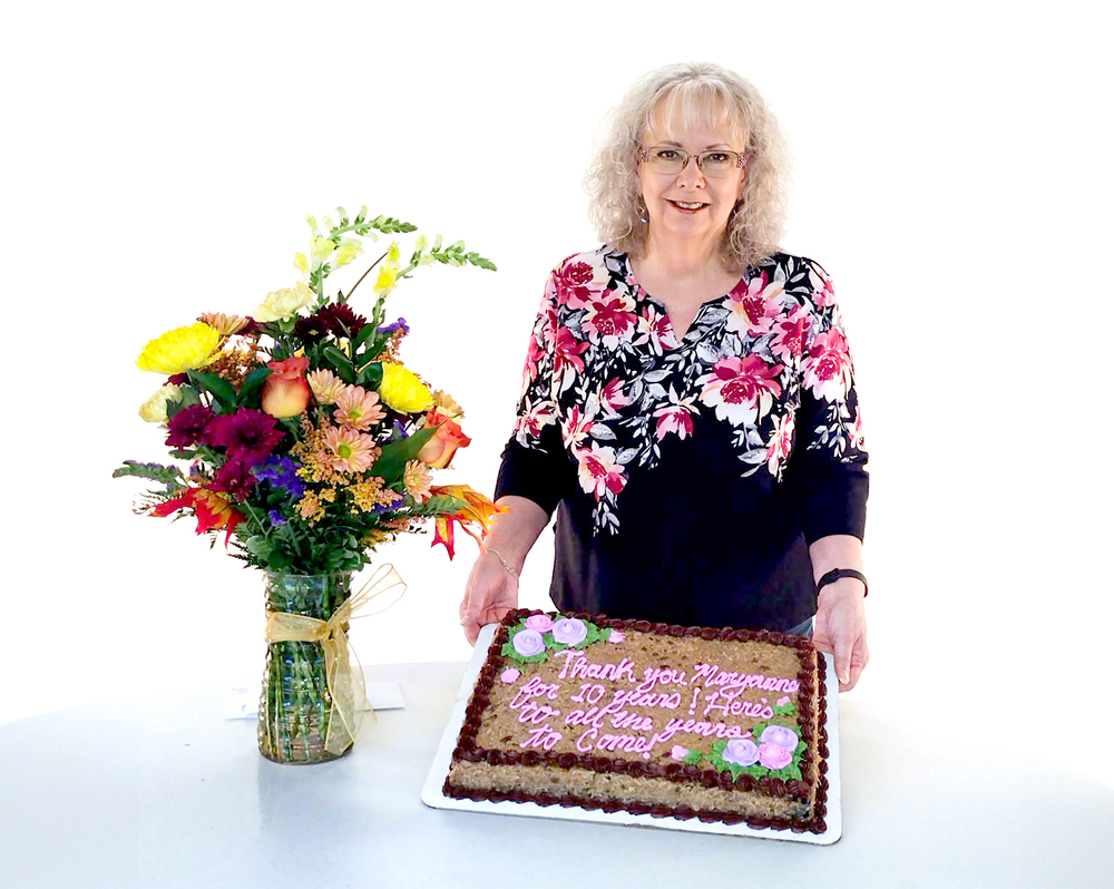 Photo of Maryanne with bouquet of flowers and German chocolate cake